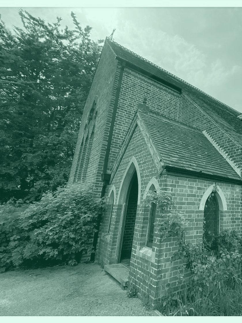 A small brick chapel among trees, in deep green duotone
