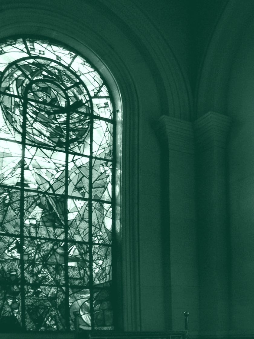Light through a tall stained-glass window, in deep green duotone