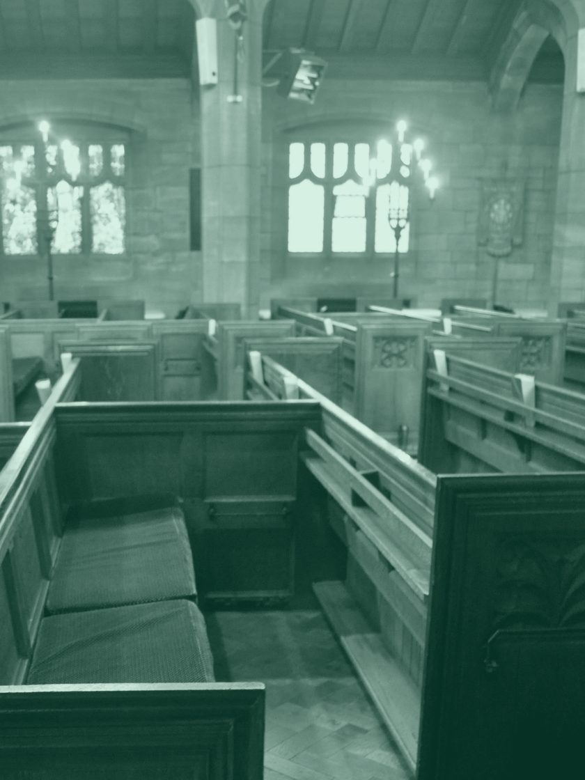 Oak pews inside a stone church, rendered in deep green duotone